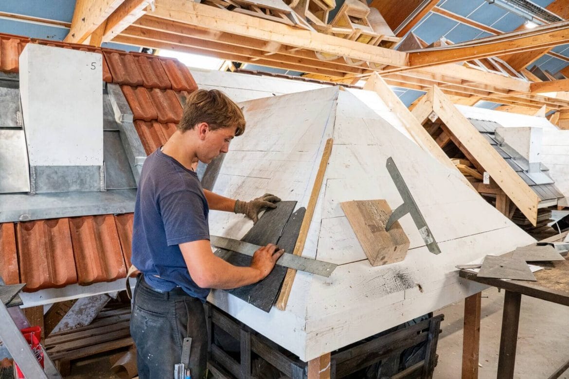 Jeune homme entrain de fabriquer un toit